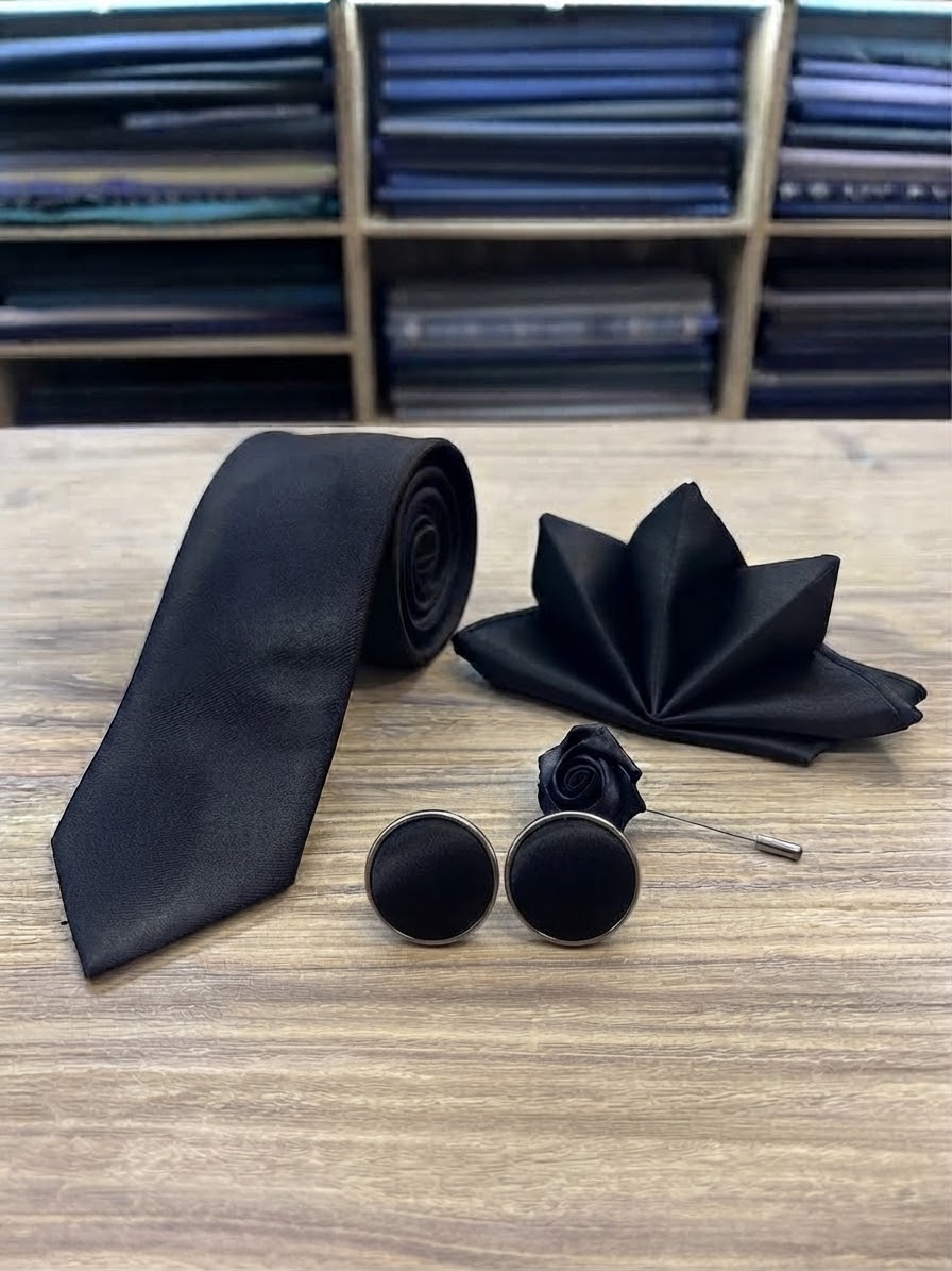 Classic black suit accessories set with necktie, cufflinks, pocket square and lapel flower pin